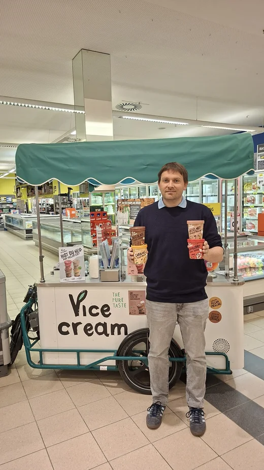 Konstantin Schlecht mit Vicecream-Bechern am Eisfahrrad im Supermarkt